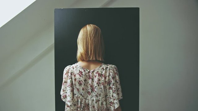Concept challenges a modern woman stands in front of a black board She hid her face Light from above