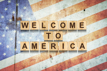 Welcome to America. The inscription on wooden blocks on the background of the flag of America. Discovery of the country after quarantine. Travels. Business.