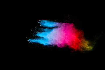 Colorful background of pastel powder explosion.Rainbow color dust splash on black background.