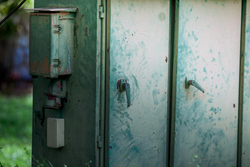 The blurred abstract background of an electric control cabinet that exists between public gardens...