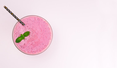 Blueberry milk smoothie in a glass on a white background. Top view. Copy space.