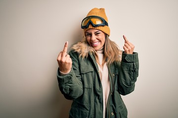 Young brunette skier woman wearing snow clothes and ski goggles over white background Showing...