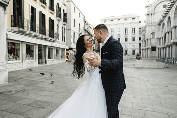 bride and groom on the background of a historic building,bride and groom walk the streets of the old city of venice,newlyweds dance,european wedding,quarantine wedding