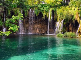 A beautiful waterfalls with turquoise lake and green background at Plitvice Lakes National Park, Croatia