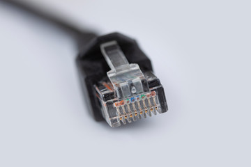 Ethernet cable plug connector. Network connection, internet communication and computer technology close-up view on white background and shallow depth of fiels. Macro photography with copy space.