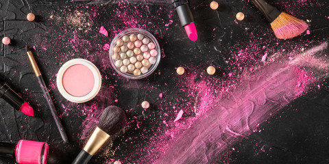 Professional makeup panorama on a black background. Brushes, lipstick and other products, a flat lay with copy space