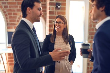 Young beautiful group of business workers smiling happy and confident, Standing with smile on face drinking coffee and speaking at the office