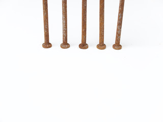 Five very rusty metal nail heads against a white background