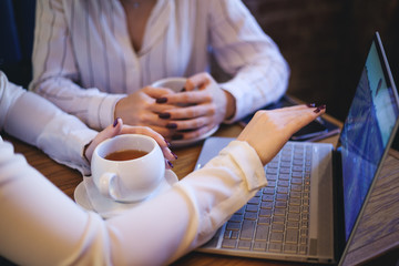 Fototapeta na wymiar Crop businesswomen using laptop in cafe