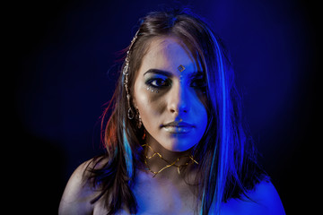 ethnic girl on a black background in blue light