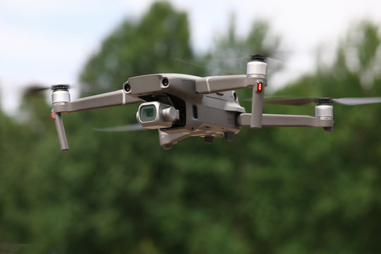 Close-up of drone quadcopter with digital camera flying in air. Equipment captures video footage. Outdoors activity with device. Remote control. Fun and photography concept