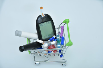 Shopping cart with digital glucometer, lancet pen and syringes and pills, medicines