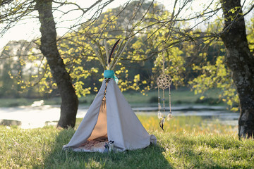 .Photo shoot with teepee and dream catcher with golden light in the river.