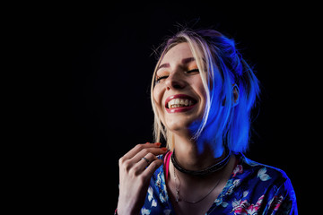 Infantile girl on a black background in blue light