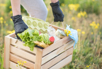 Fototapeta premium man holding a basket with vegetables. fresh vegetables in a basket. picnic in the garden. Coronavirus. Woman with face mask on quarantine. Stay at home. Enjoy cooking at home. Family concept. 