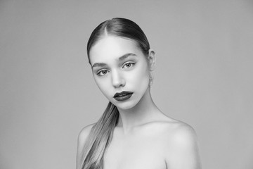black and white portrait of attractive sexy woman with red lips posing grey background. Beautiful healthy face of the young pretty woman with fresh skin.