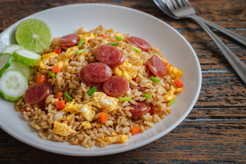 Fried rice with chinese sausage on plate .