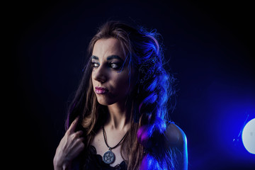 Girl in werewolf style on a black background with blue light