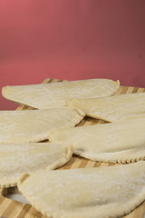Cold chebureks with stuffing, on wooden blackboard.