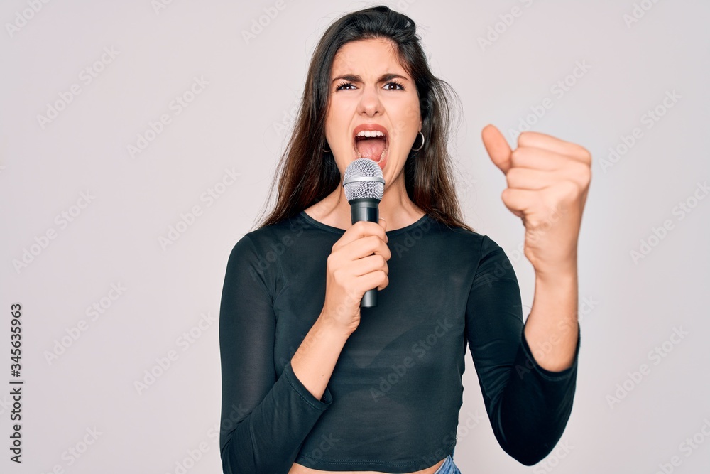 Poster young beautiful singer performer girl singing using music microphone over isolated background annoye