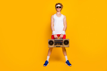 Full length body size view of nice funky thin cheerful cheery positive glad guy holding in hands carrying boombox dj party isolated over bright vivid shine vibrant yellow color background