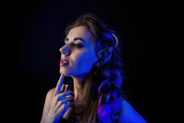 Obraz premium Girl in werewolf style on a black background with blue light