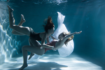 Two beautiful lesbian girls are swimming underwater. Attractiveness. Sexual poses and gestures....