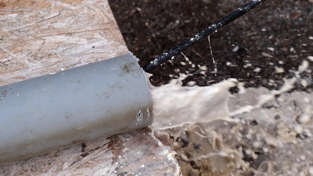 Сlean a clogged sewer pipe. A plumber shows how to clean a clogged sewer pipe using cleaning tool. Close-up. Slow motion.