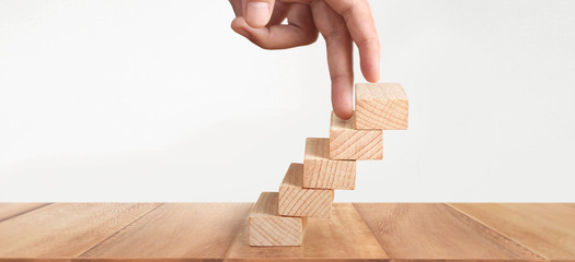 Hand liken person stepping up  toy staircase wood