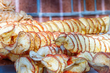 Round potato chips skewered outside on a bright sunnyday