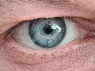 Close-up of mature mans blue eye ball. Middle-aged males face with wrinkles. Detailed picture of person. Eyebrow and eyelash. Ageing millennial skin concept - obrazy, fototapety, plakaty