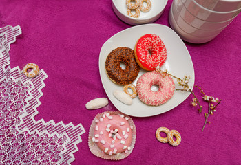 donuts in a plate on a pink background