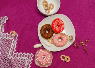 donuts in a plate on a pink background