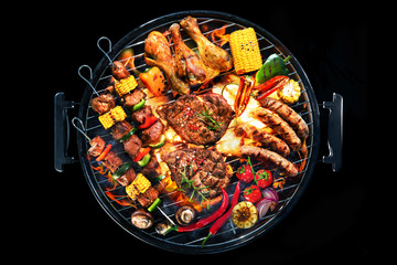 Top view of assorted delicious grilled meat with vegetables on barbecue isolated on black background