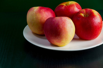 Apples, red, yellow, four fruits, white plates, black wood flooring, green walls