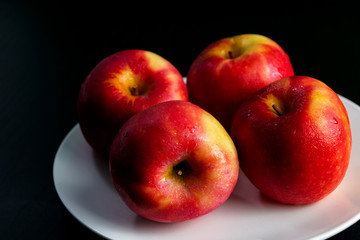 Apples, red, yellow, four fruits, white plates, black wood flooring, green walls