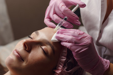 Beautiful girl on rejuvenation procedure in beauty clinic filler injection.