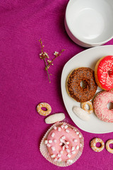 donuts in a plate on a pink background