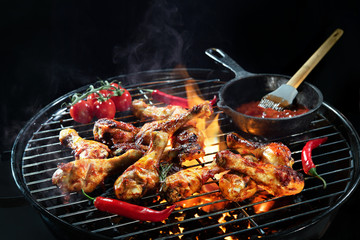 Grilled chicken legs or drumsticks on the hot flaming grill
