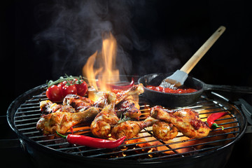Grilled chicken legs or drumsticks on the hot flaming grill