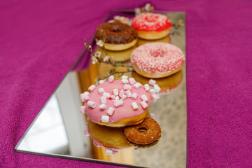 multi-colored donuts on a mirror surface