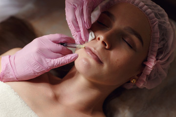 Beautiful girl on rejuvenation procedure in beauty clinic filler injection.