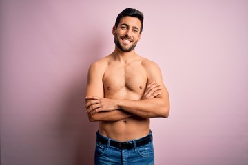 Young handsome strong man with beard shirtless standing over isolated pink background happy face smiling with crossed arms looking at the camera. Positive person.