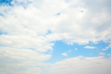Huge clouds in blue sky lit by the sun, not windy.
