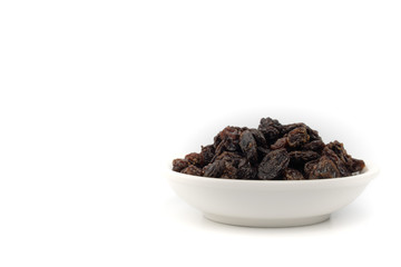 Dried black raisin in white bowl isolated in white background.