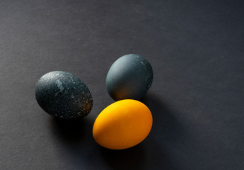 Three colored balls (eggs) on a black background.