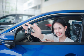 Beautiful Asian women smile on the phone at the new car showroom. Female car dealer Car dealer and rental concept background