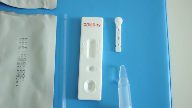 Laboratory assistant lays out a kit for the diagnosis of sars-cov-2 coronovirus - test cassette, reagents, scarifier and disinfectant wipe. Rapid Test Coveid-19