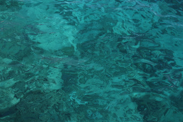 Emerald texture of sea water. Photo through the surface of the water. Transparent and clear