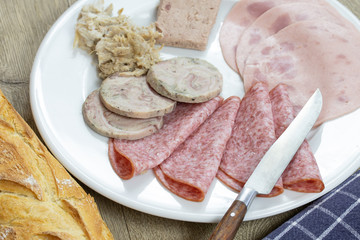 assiette de charcuterie et baguette de pain sur une table